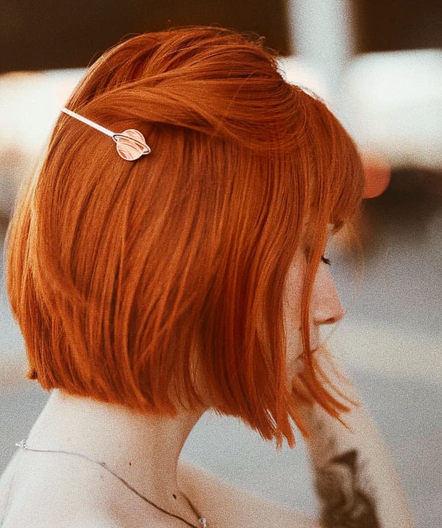 Hot hi-pigment burnt-orange hair color on blunt-cut short bob